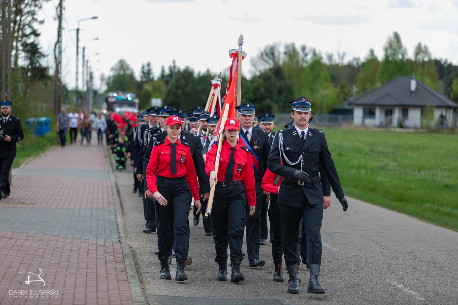 strażacy maszerują z kościoła do osp 